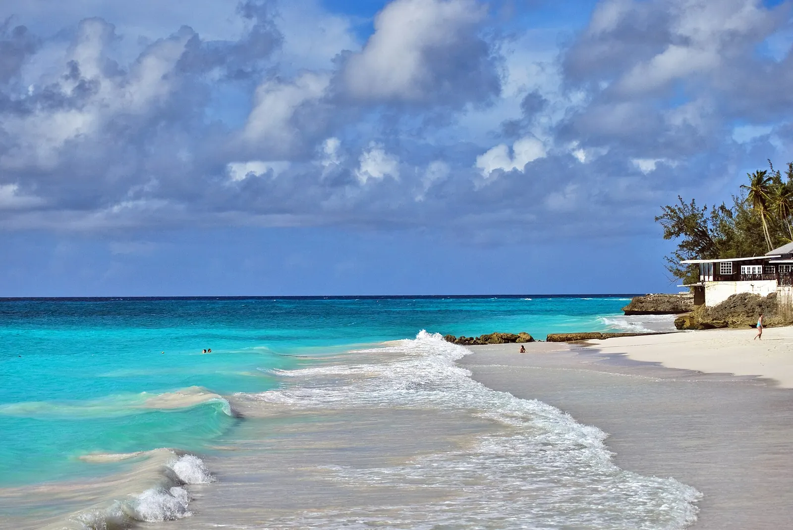 Des vagues sur une plage de sable blanc à l'eau turquoise, à la Barbade